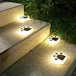 Estaca huellitas de perro iluminando jardín con luz LED cálida