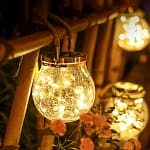 Frasco craquelado solar colgando con luz cálida en jardín al anochecer