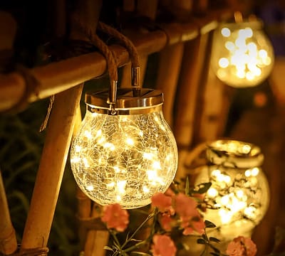 Frasco craquelado solar colgando con luz cálida en jardín al anochecer