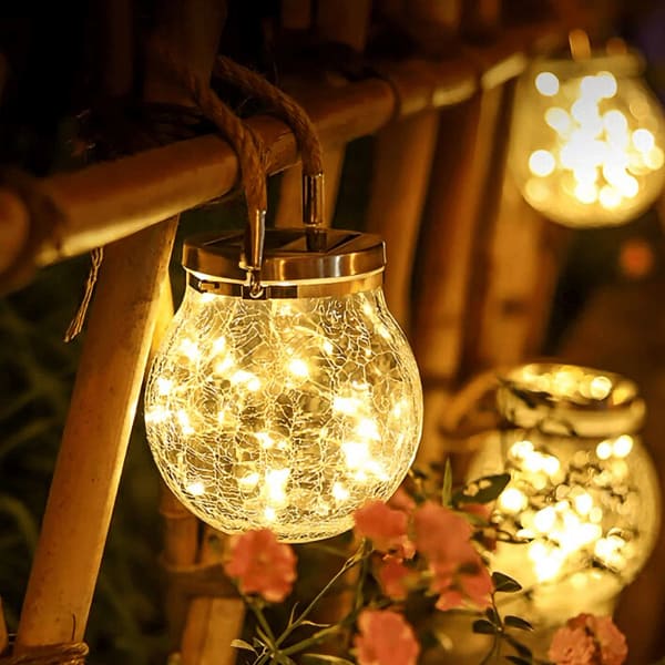 Frasco craquelado solar colgando con luz cálida en jardín al anochecer