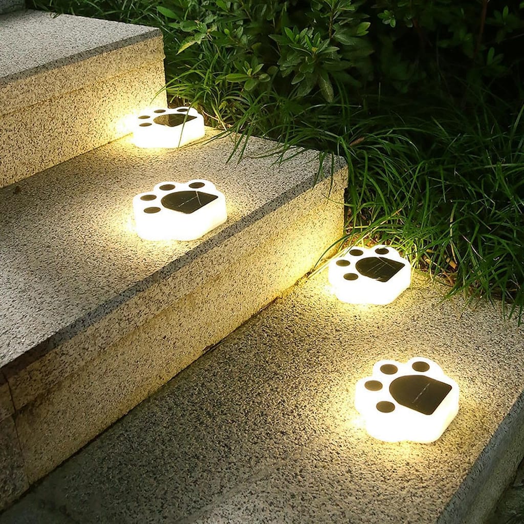 Estaca huellitas de perro iluminando jardín con luz LED cálida